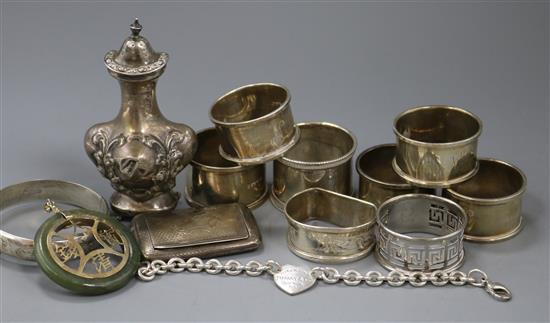 Seven assorted silver napkin rings, silver pepper, silver snuff box, bracelet and three other items.